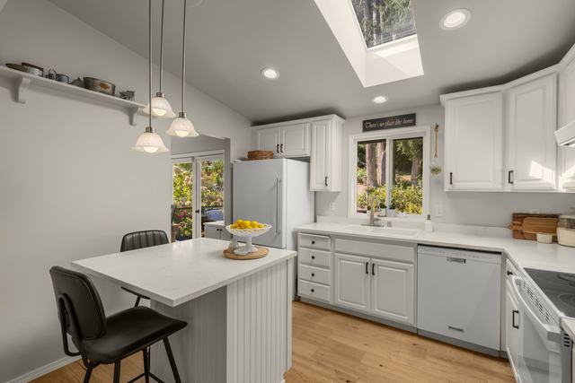 Kitchen: quartzite counters, island seating, skylight overhead